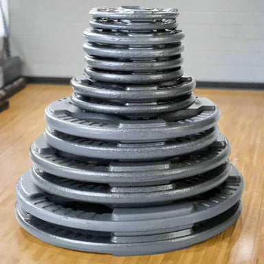 Body-Solid Cast Iron Grip Olympic Plates Set Stacked inside Gym Floor