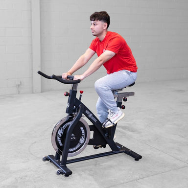 A man in a side view using Body Solid Best Fitness BFSB5B Indoor Training Cycle