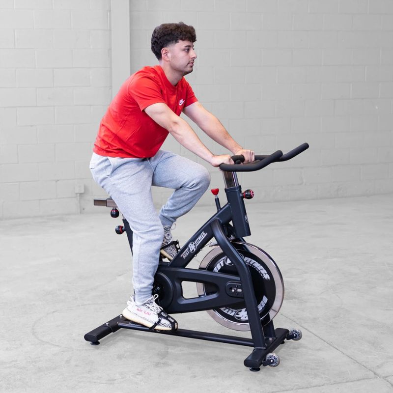 A man working out using Body Solid Best Fitness BFSB5B Indoor Training Cycle side view